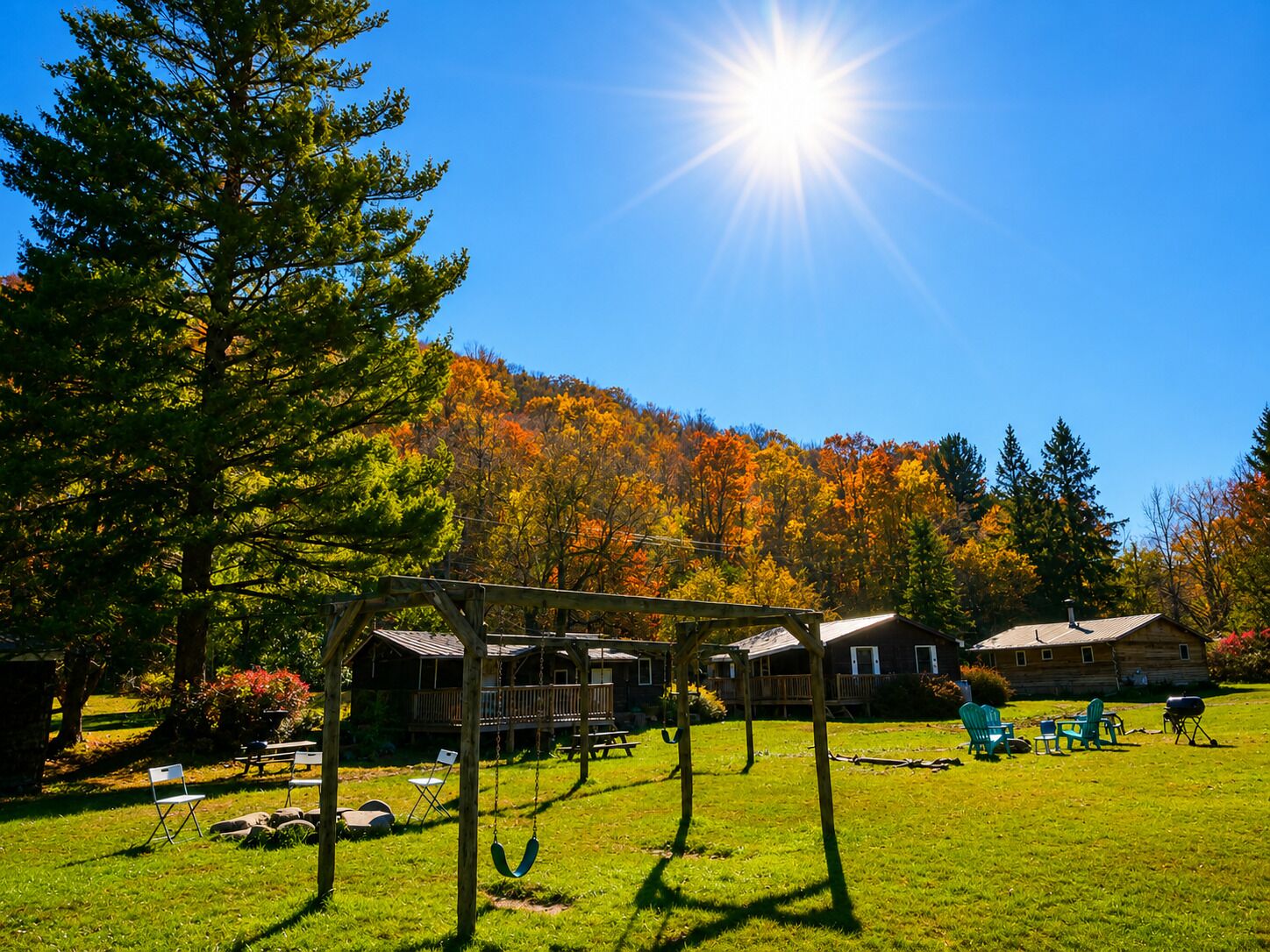 A lodge with a wooden deck, outdoor seating, and a view of a forested mountain.