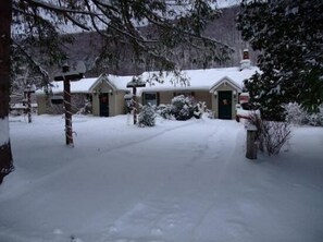 A snow-covered building with a driveway leading to the entrance.