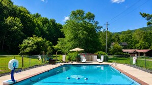 A rectangular swimming pool with a tiled edge, surrounded by a brick deck.