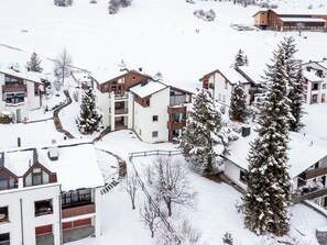 A snow-covered residential area with modern houses, a ski lift, and a clear sky. - Collina 5i-02 by Interhome (Flims)