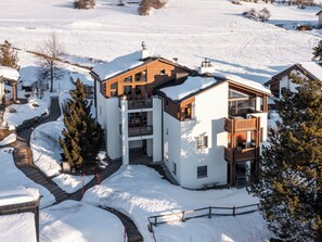 A modern multi-story house with a covered outdoor area, surrounded by snow-covered landscape. - Collina 5i-02 by Interhome (Flims)