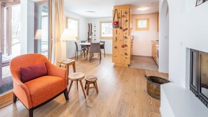 A modern living room with a fireplace, a dining area, and a kitchen. - Collina 5i-02 by Interhome (Flims)