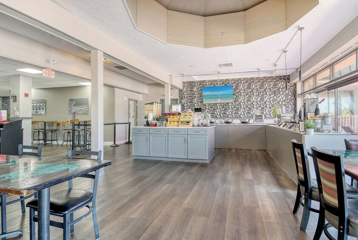 Een moderne keuken met een centraal eiland, een bar en een uitzicht op de stad door grote ramen.