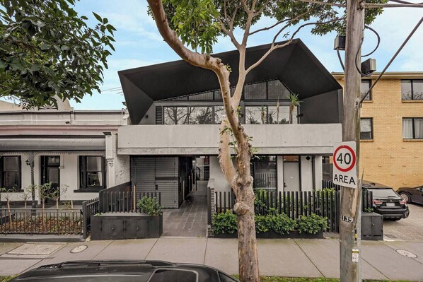 A modern two-story building with a flat roof and a speed limit sign indicating 40 km/h.
