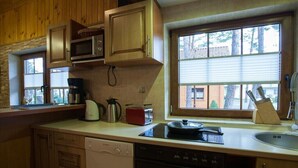 Une cuisine avec des meubles de rangement en bois, un four à micro-ondes, un grille-pain et un évier.