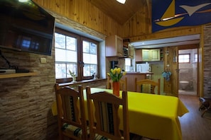 Ein Holzinterieur mit Essbereich, Küche und Bad.