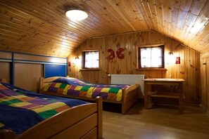 A wooden cabin bedroom with two beds, a desk, and a window. - Four -anniversary Type B (Dzwirzyno)