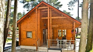 Una baita di legno con un portico, una porta e una finestra.