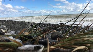 Une côte rocheuse où les vagues se brisent sur le rivage.