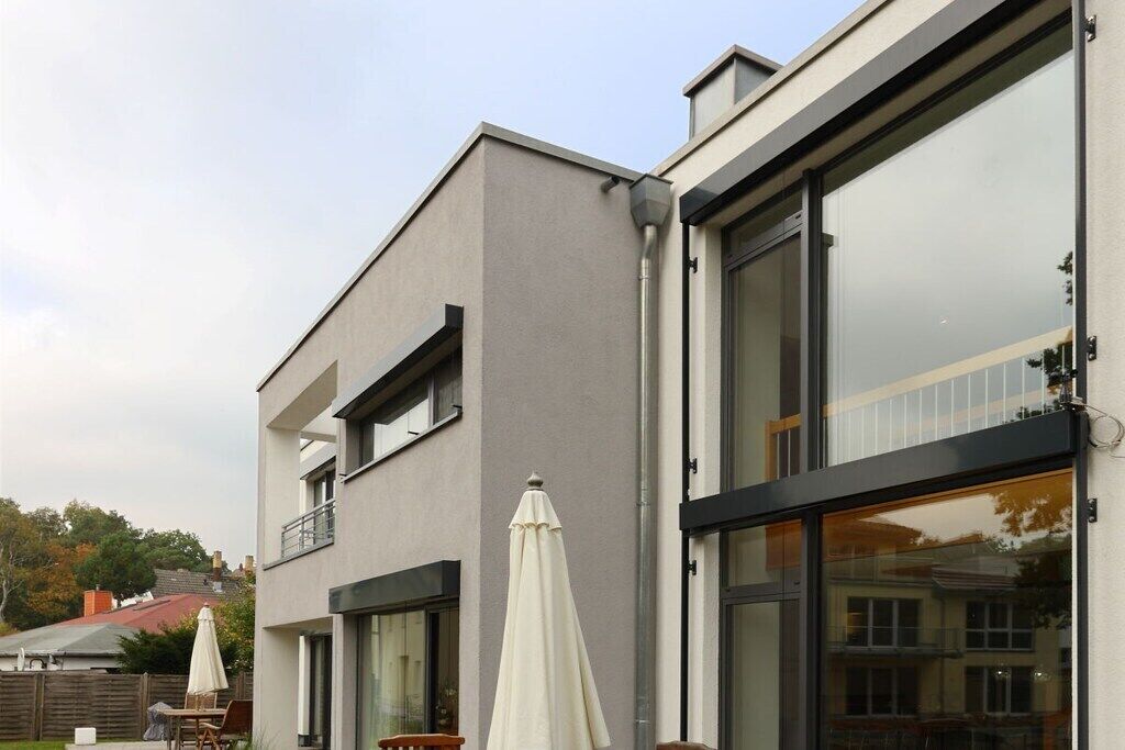 A modern two-story building with large windows and a balcony.