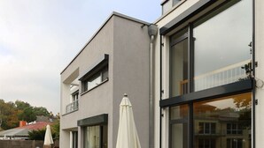 Un immeuble moderne à deux étages, doté de grandes fenêtres et d’un balcon.
