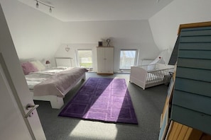 A bedroom with a bed, a crib, a wardrobe, and a window. - Old Tenne under Reet in a single position (Taarstedt)