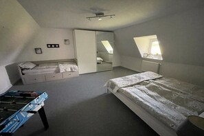 A bedroom with a bed, a wardrobe, a desk, and a window. - Old Tenne under Reet in a single position (Taarstedt)