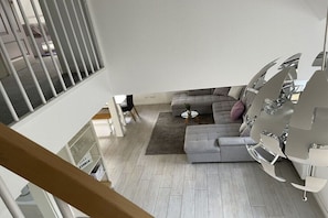 A modern living room with a grey sofa, a small round table, and a white radiator. - Old Tenne under Reet in a single position (Taarstedt)