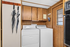 A laundry room with a washer and dryer, wooden cabinets, and a window. - Close to Beach & Dtwn! Extended Long Beach Stay (Long Beach)