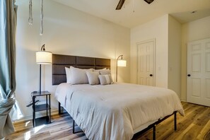 Une chambre à coucher avec un lit, des lampes de chevet, une tête de lit et une porte.