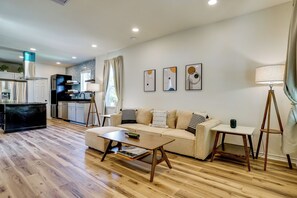 A modern living space with a sofa, coffee table, and a dining area. - Historic Southside Fort Worth Home w/ Fenced Yard! (Fort Worth)