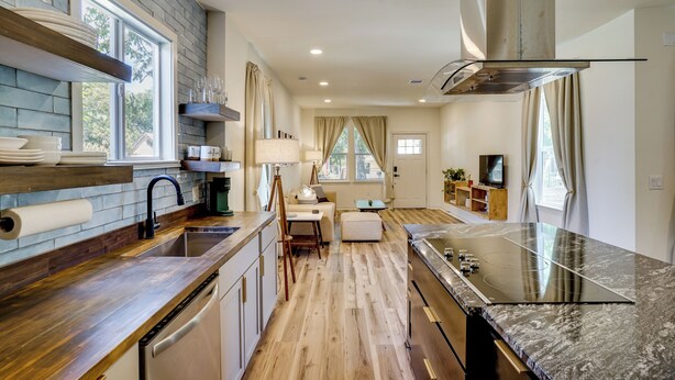 A modern kitchen with a wooden countertop, built-in appliances, and a dining area with a table and chairs. - Historic Southside Fort Worth Home w/ Fenced Yard! (Fort Worth)