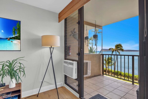 Un balcon avec vue sur la mer, un lampadaire et des unités de climatisation.