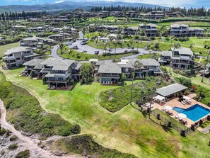 A residential area with multiple two-story houses, a swimming pool, and well-maintained lawns. - 2BR, 3BA Oceanfront retreat with pool, balcony, and beach access-Kapalua Bay Villas 23B3 (Lahaina)