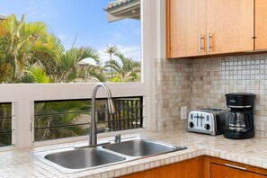 A kitchen with a double sink, a coffee maker, and a toaster. - 2BR, 3BA Oceanfront retreat with pool, balcony, and beach access-Kapalua Bay Villas 23B3 (Lahaina)