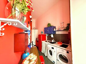 Een kleine keuken met een wasmachine, een koelkast en een spoelbak.