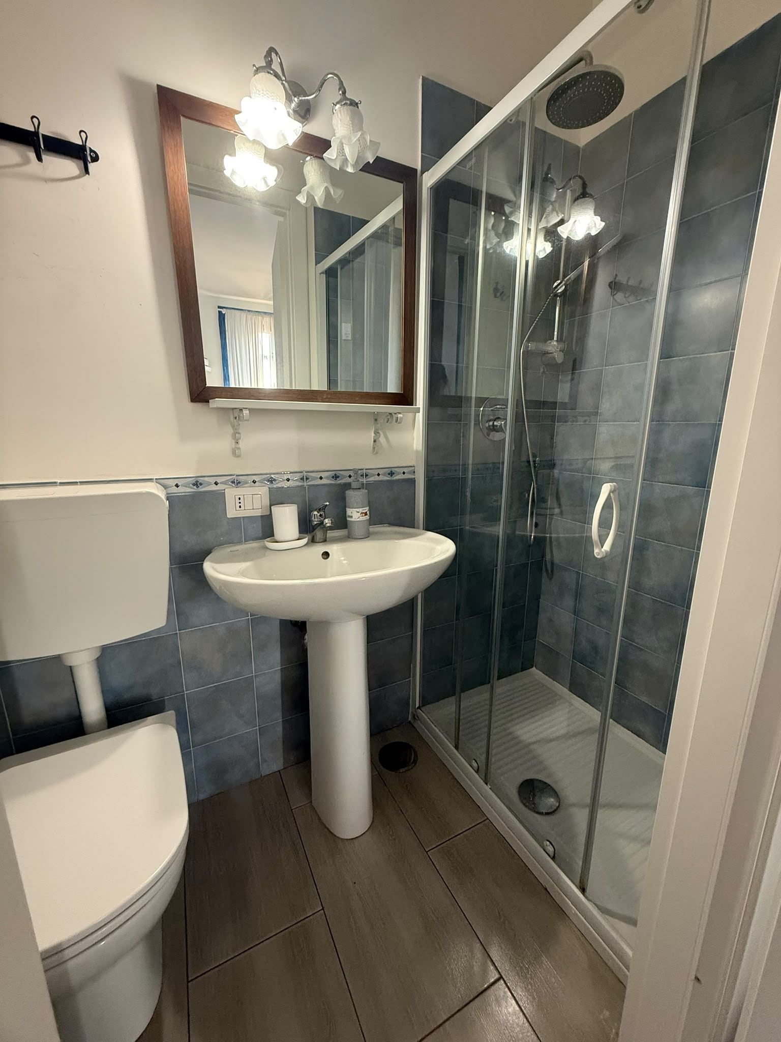 Een badkamer met toilet, wastafel en douchecabine.