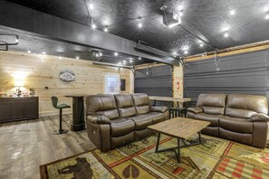 A cozy interior with a leather sofa, a small table, and a wooden wall with a logo.