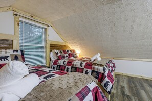 A bedroom with two beds, a window with blinds, and a sloped ceiling. - Pond View & Hot Tub! 'The Perch' in Hocking Hills (Rockbridge)
