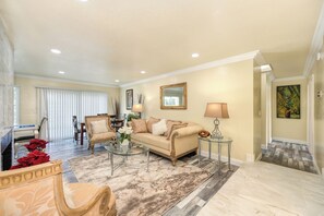 A living room with a sofa, armchairs, a coffee table, and a dining area with a table and chairs. - Near Golden 1 Center! Modern Home w/ Ping-Pong (Sacramento)