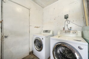 A laundry room with two washing machines, a control panel, and a power outlet on the wall. - Near Golden 1 Center! Modern Home w/ Ping-Pong (Sacramento)