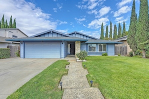 A single-story house with a blue garage, a front porch, and a well-maintained lawn.