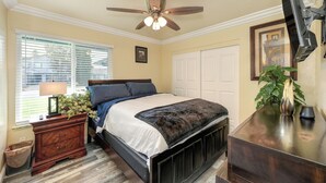A bedroom with a bed, bedside table, lamp, window with blinds, ceiling fan, and a plant. - Near Golden 1 Center! Modern Home w/ Ping-Pong (Sacramento)