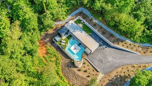 Vue aérienne d’une propriété dotée d’une piscine, d’un jacuzzi et d’un patio couvert.