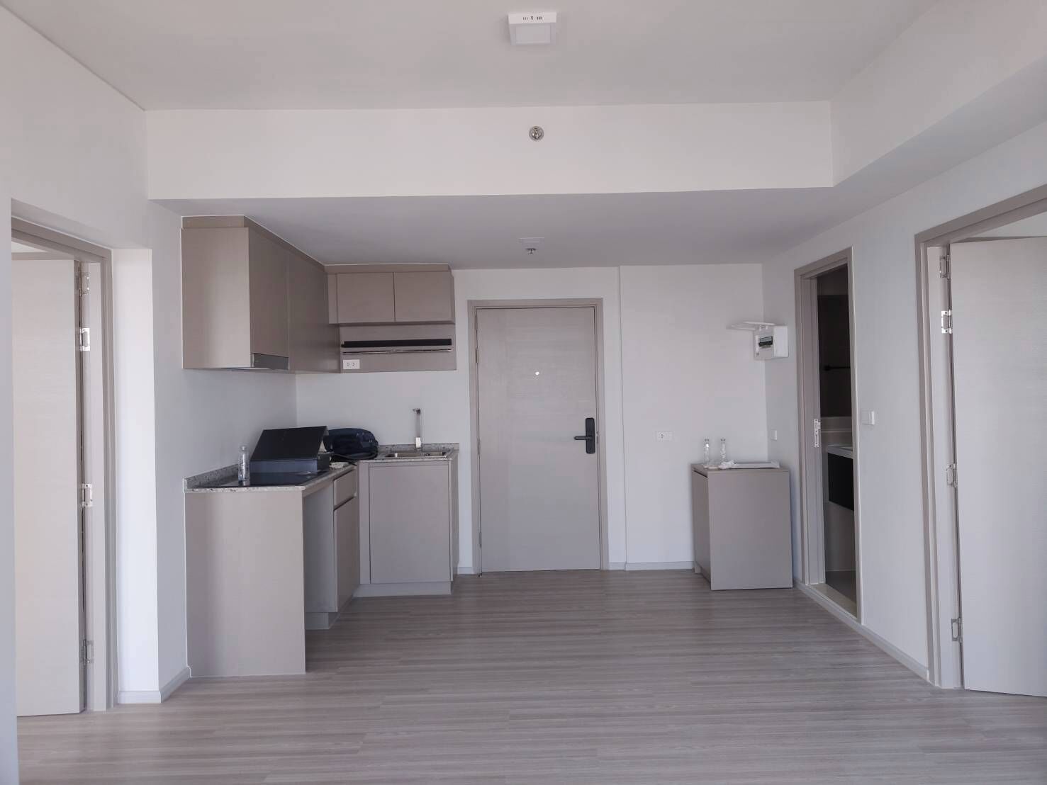 Una cuina moderna amb armaris integrats, una encimera i una porta que dona a una altra habitació.