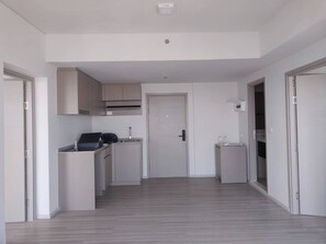A modern kitchen with built-in cabinets, a countertop, and a door leading to another room. - Exclusive Holiday House in Thon Buri with River Views (Thon Buri)