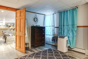 Ein Zimmer mit Holztür, einem Schminktisch, einem Heizkörper und einem gemusterten Teppich.
