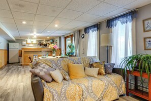 Ein gemütliches Wohnzimmer mit einer Couch, einem Esstisch und einer Küche im Hintergrund.