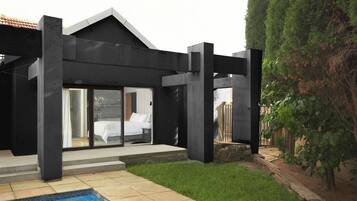Una casa moderna con piscina, amplios ventanales y un camino de piedra.