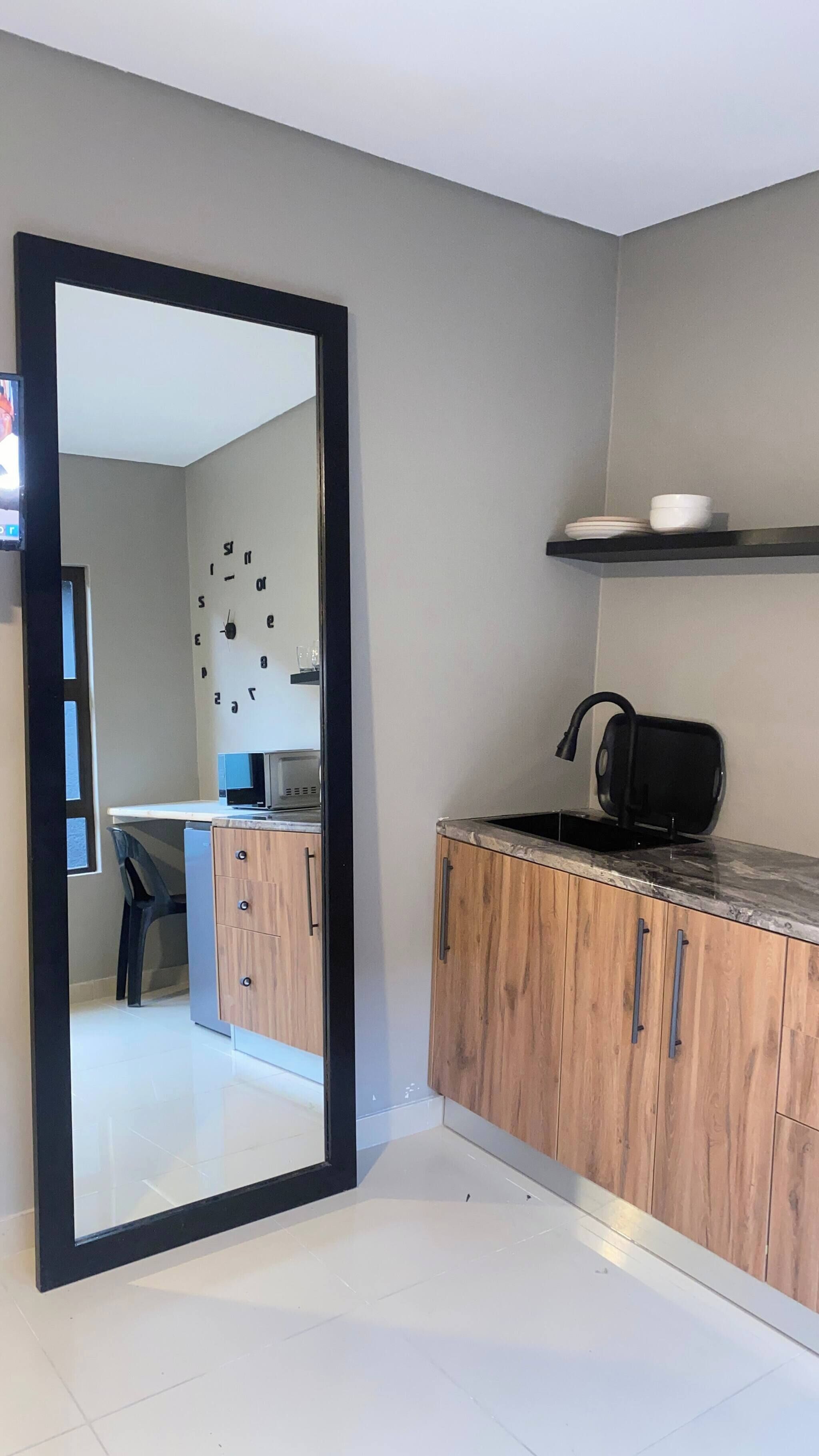 A modern kitchen with a microwave, a sink, and wooden cabinets.