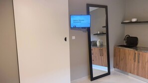 Une cuisine moderne avec des meubles en bois, un four à micro-ondes et une machine à café posés sur le plan de travail.
