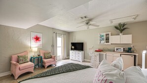 A bedroom with a bed, a TV, a desk, and a kitchenette. - Lanai, Pool Access! Naples Studio Near Beach (Naples)