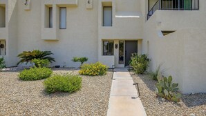 A modern building with a courtyard, featuring a pathway leading to the entrance, surrounded by various plants and a cactus. - Walk to El Paseo Shops! Palm Desert Condo w/ Patio (Palm Desert)