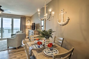 A dining area with a table set for four, a chandelier, and decorative anchors on the wall. - Gulf Views & Beach Access! 2 PCB Condos w/ Pool! (Panama City Beach)