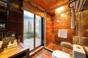 Een moderne badkamer met douche, toilet en een groot raam.