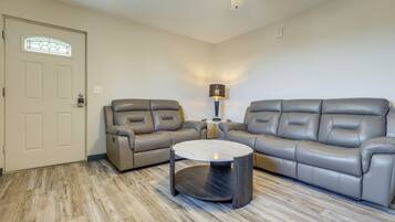 A living room with two sofas, a coffee table, and a ceiling fan.