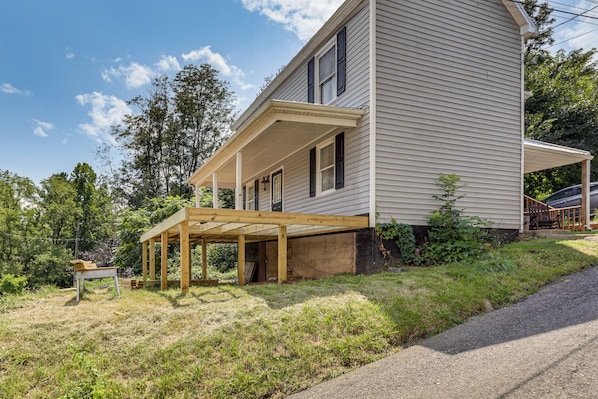 A two-story house with a covered porch and a wooden deck.