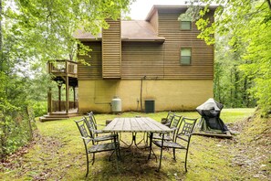 A wooden cabin with a deck, a covered grill, and a table with chairs in a wooded area. - Family Friendly! Scenic Murphy Escape w/ Fire Pit (Murphy)