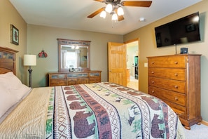 A bedroom with a bed, dresser, mirror, ceiling fan, and a television on the wall. - Family Friendly! Scenic Murphy Escape w/ Fire Pit (Murphy)