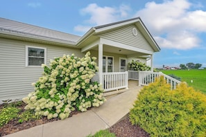 A two-story house with a covered porch, a large hedge, and a well-maintained lawn. - Family-Friendly Goshen Home Near Amish Country (Goshen)